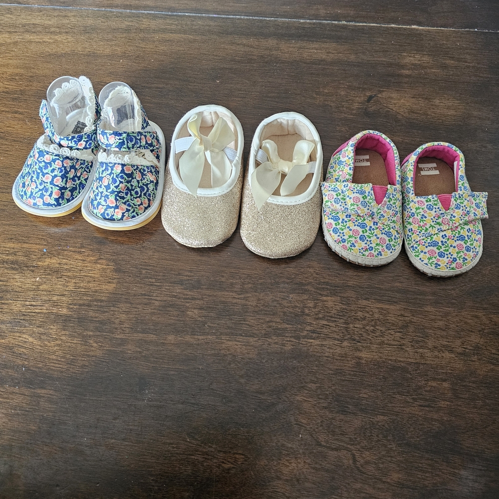 3 pairs of baby/girl shoes—soft, floral, and glittery—in various styles.